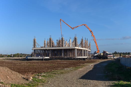 machine for pouring concrete at the construction site of a new complex near the sea