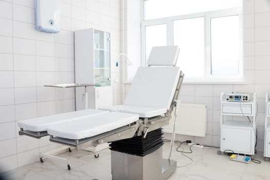 Hospital interior design with operating table and lamp with cabinets and modern devices in light surgery room