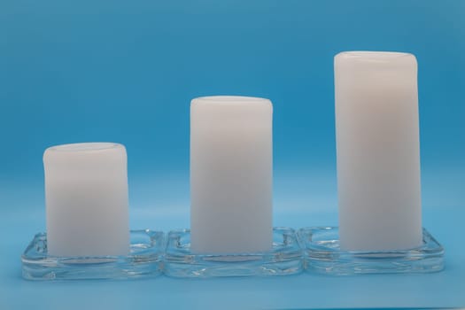 A beautiful composition of three elegant candles placed on a small glass plat, creating a serene and peaceful ambiance
