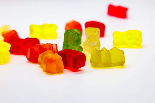 A vibrant and colorful arrangement of gummy bears is showcased against a clean, white backdrop
