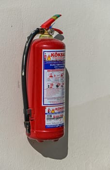 Fire extinguisher on a light wall in a residential complex