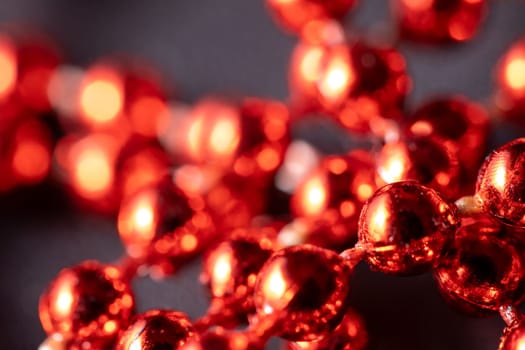 Red and bright Christmas pearls, Christmas tree decorations, garlands, decorations. Close-up macro photography