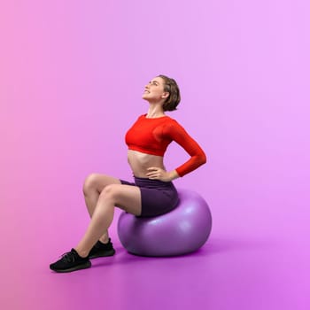 Full body length gaiety shot athletic and sporty young woman with fitness exercising ball in standing posture on isolated background. Healthy active and body care lifestyle.