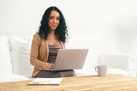 African-American woman using laptop computer for crucial work on internet. Secretary or online content writing working at home.