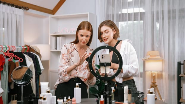 Two influencer partner shoot live streaming vlog video review makeup prim social media or blog. Happy young girl with cosmetics studio lighting for marketing recording session broadcasting online.