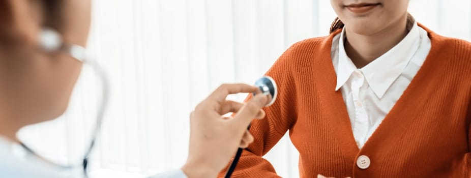 Patient attend doctor's appointment at clinic or hospital office. Doctor examining and diagnosis symptoms while checking the patient's pulse with stethoscope. Panorama Rigid