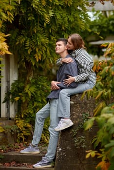 Joyful Autumn Embrace: Cute Lovers Strolling in the Park. Young Cute Female Hugs Boyfriend. In Autumn Outdoor. Lovers Walking in Park. Attractive Funny Couple. Lovestory in Forest. Man and Woman. Cute Lovers in the Park. Family Concept. Happy Couple.