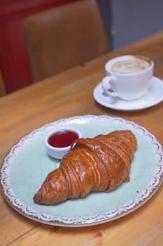 fresh baked croissant on plate with copy space . High quality photo