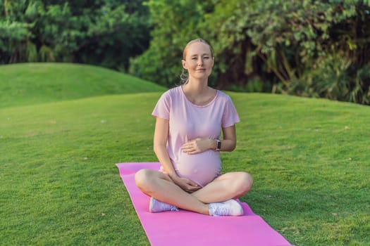 Energetic pregnant woman takes her workout outdoors, using an exercise mat for a refreshing and health-conscious outdoor exercise session.