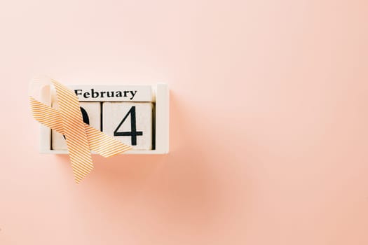 Pink awareness ribbon sign and Calender 4 February of World Cancer Day campaign on pastel pink background with copy space, concept of medical and health care support