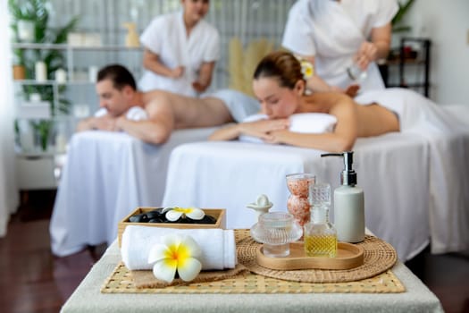 Aromatherapy massage on daylight ambiance or spa salon composition setup with focus decor and spa accessories on blur woman enjoying blissful aroma spa massage in resort or hotel background. Quiescent