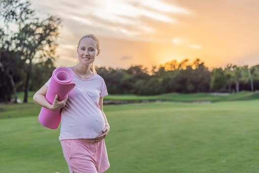 Energetic pregnant woman takes her workout outdoors, using an exercise mat for a refreshing and health-conscious outdoor exercise session.