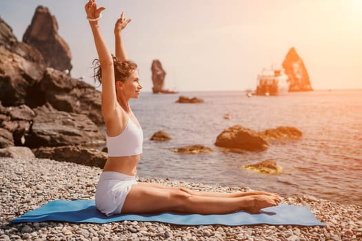 Woman sea yoga. Back view of free calm happy satisfied woman with long hair standing on top rock with yoga position against of sky by the sea. Healthy lifestyle outdoors in nature, fitness concept.