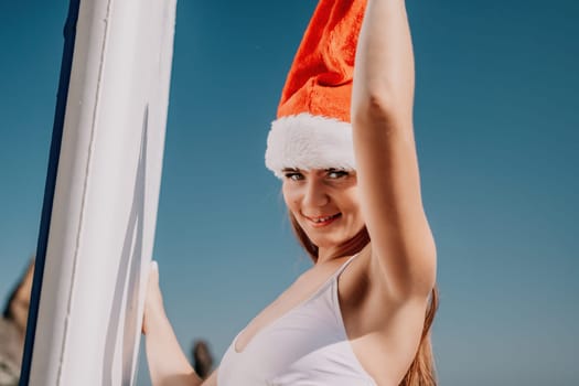 Close up shot of happy young caucasian woman looking at camera and smiling. Cute woman portrait in bikini posing on a volcanic rock high above the sea