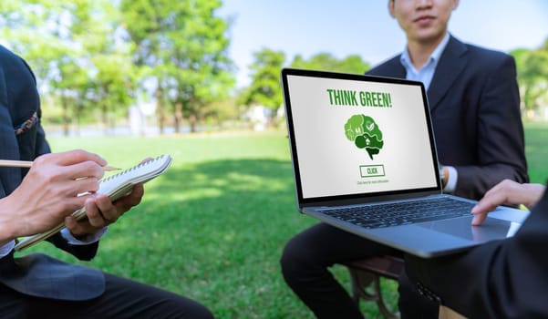 Group of asian business people planning on environmentally friendly development plan on laptop screen and sustainable technology project for greener future, outdoor eco office at natural park. Gyre