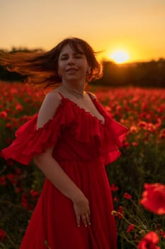 Woman poppy field red dress sunset. Happy woman in a long red dress in a beautiful large poppy field. Blond stands with her back posing on a large field of red poppies.