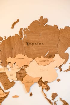 Wooden world map on the wall the continent of Asia. Ivano-Frankivsk, Ukraine March 26, 2023
