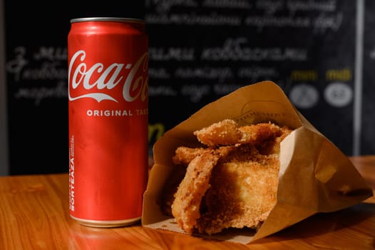 Ivano-Frankivsk, Ukraine March 26, 2023: Coca Cola and fried chicken nuggets on the table, a quick snack in a cafe.