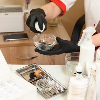 Ivano-Frankivsk, Ukraine May 17, 2023: A cosmetologist collects a transparent gel in a bowl for application on the face, a drug for carboxytherapy.