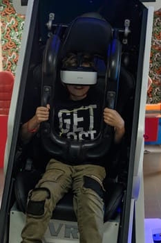 Ivano-Frankivsk, Ukraine June 7, 2023:A guy is sitting on a ride with vr glasses, 5d and adrenaline from virtual reality.
