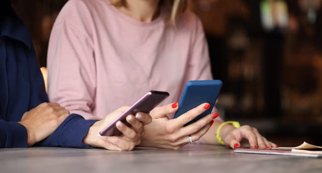 Two people are holding smartphones in their hands. Modern gadget addiction concept