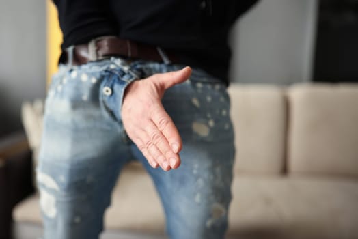 Man offers a handshake through fly of his pants. Business fraud concept