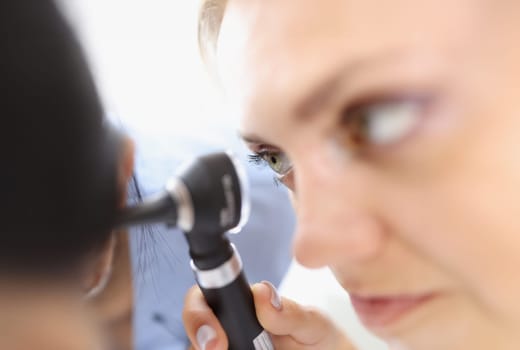 An otolaryngologist examines the patient's ear. Hearing diseases and ear diseases concept