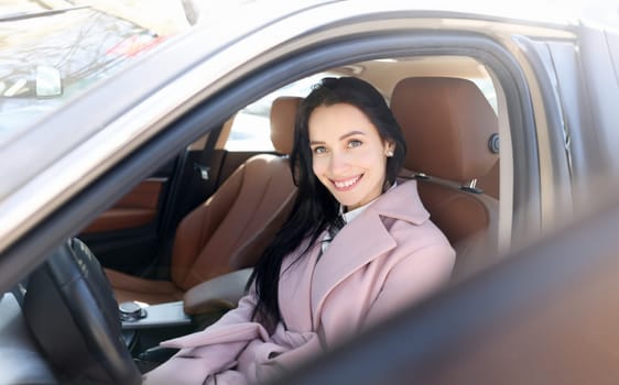 Rent car concept. Smiling woman sit on modern brown car portrait. Registration of vehicles