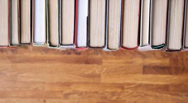 Books are in row on a wooden table. Promotion of books and reading in library