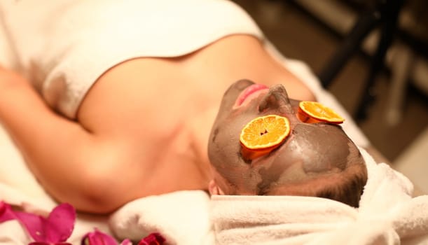 Woman lying in spa salon with moisturizing mask on her face. Skin care concept