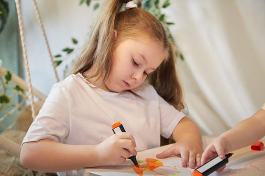 Cute little girl are painting on table. Preschooler 7 years child in living room. Teenager girl kids doing school homework. Home schooling concept