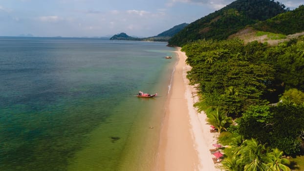 A beautiful view of a calm beach with crystal clear water on the blue sky at Koh Libong, Trang province, Thailand, Andaman Sea on a sunny day