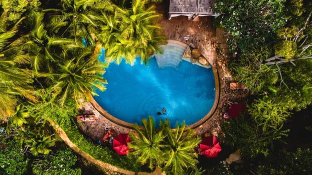 aerial drone view of a swimming pool in the jungle of Krabi Thailand, aerial view with a drone above a swimming pool in the rainforest of Thailand.