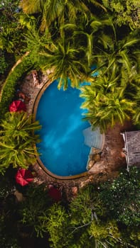 aerial drone view of a swimming pool in the jungle of Krabi Thailand, aerial view with a drone above a swimming pool in the rainforest of Thailand.