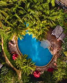 aerial drone view of a swimming pool in the jungle rainforest in Thailand, aerial view with a drone above a swimming pool in the rainforest of Thailand.
