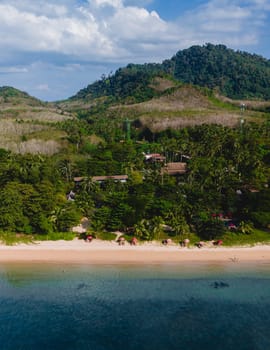 A beautiful view of a calm beach with crystal clear water on the blue sky at Koh Libong, Trang province, Thailand, Andaman Sea with mountains on the beackground