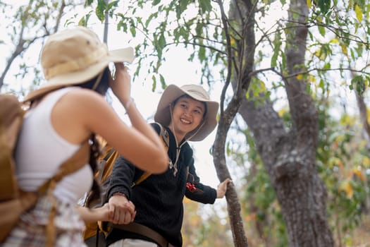 Lovely couple lesbian woman with backpack hiking in nature. Loving LGBT romantic moment in mountains.