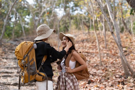 Lovely couple lesbian woman with backpack hiking in nature. Loving LGBT romantic moment in mountains.