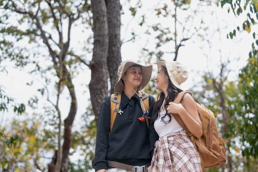 Lovely couple lesbian woman with backpack hiking in nature. Loving LGBT romantic moment in mountains.