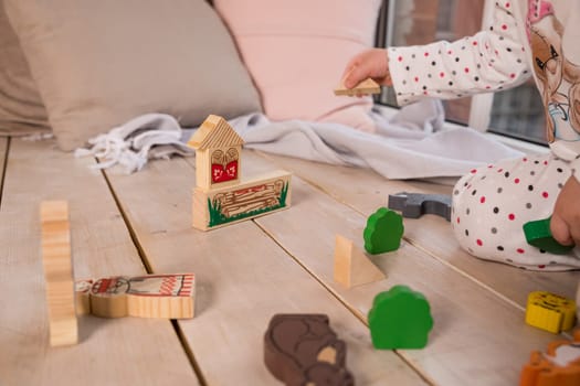 Tiny colorful wooden toy shapes and building blocks on hardwood floor. Macro with extremely shallow dof. Selective focus on toys in foreground.