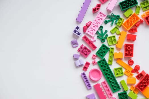 Developing children games frame. Colorful plastic bricks and blocks on yellow background top view space for text