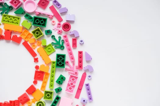 Developing children games frame. Colorful plastic bricks and blocks on yellow background top view space for text