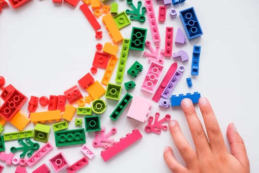 Cute little baby boy playing with colorful educational toys on the play mat in the home interior.