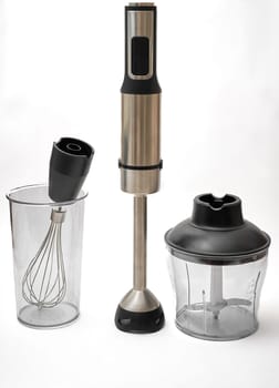 Immersion hand blender with various attachments and two cups. Electric kitchen appliances for making sauces, smoothies, purees. Hand mixer set.