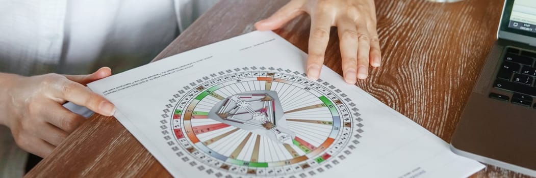 Tver, Russia - August 2, 2021. A woman in a cafe at a table is studying the design of a person. The concept of studying esoteric sciences. A bodigraph or a map of a person on an A4 sheet