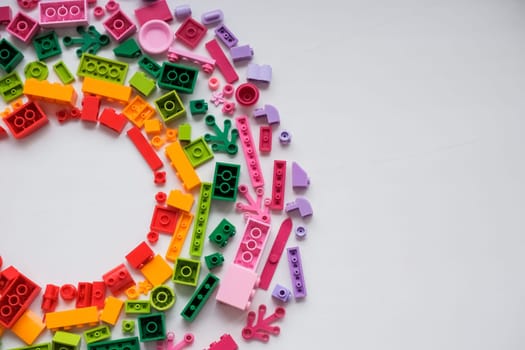 Developing children games frame. Colorful plastic bricks and blocks on yellow background top view space for text