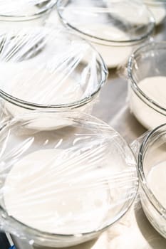 Mixing ingredients in a large glass mixing bowl to make homemade royal icing.