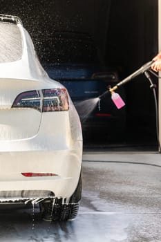 Efficiently cleaning an electric car in the comfort of a suburban driveway, combining eco-consciousness with practicality.