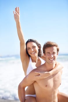 Portrait, energy and piggyback with couple on beach together for holiday, vacation or romantic getaway. Smile, travel or love with happy young man and woman by ocean or sea for coastal adventure.