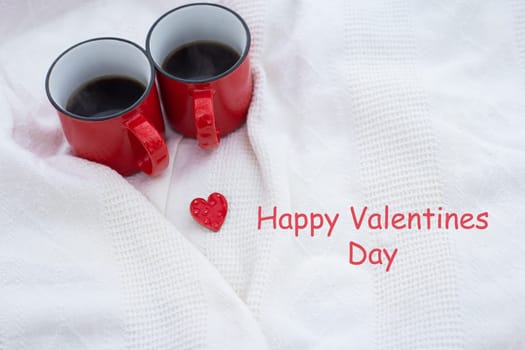 Romantic still life, two red cups of coffee on a white plaid. Valentine's Day lettering, holiday card